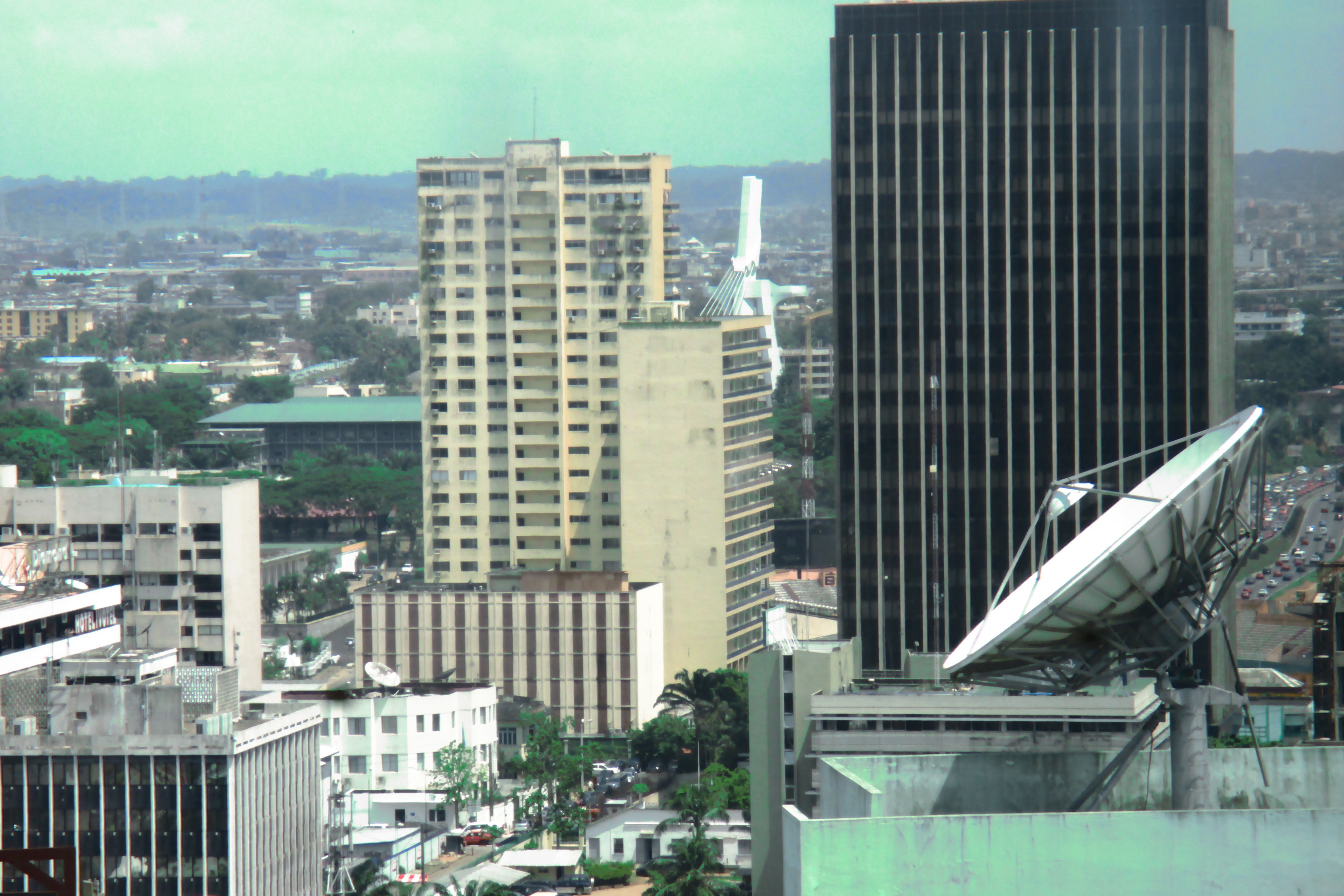 Abidjan, Plateau, from behind the green tinted windows of the entirely refurbished Africa Development Bank headquarters. The white structure in the middle belongs to the St. Paul's Cathedral, built in the first half of the 1980s. 